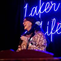 An alumni speaker laughs on stage